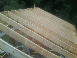 New roof rafters set over an addition before sheathing in Grassy Creek