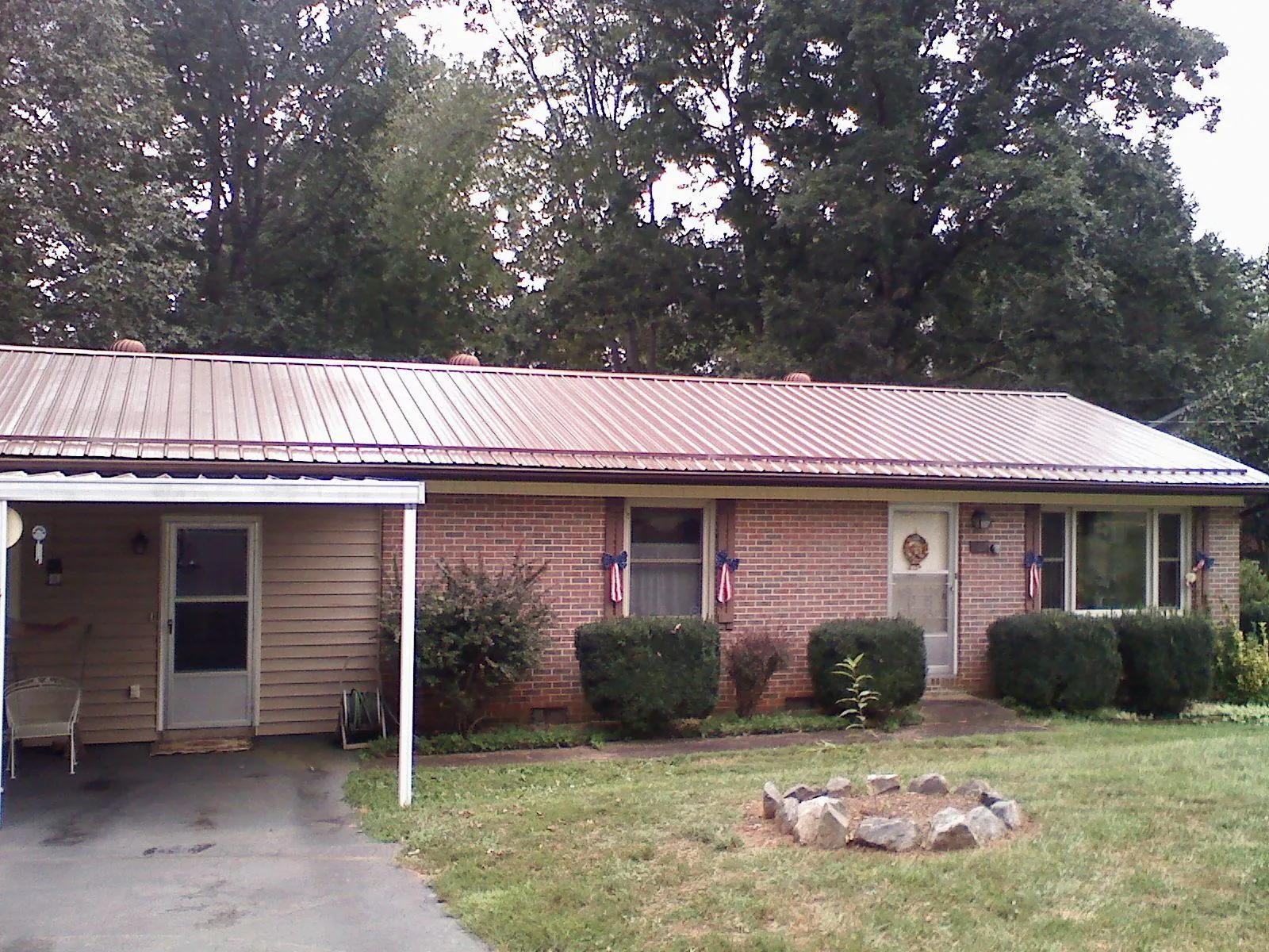 Bronze metal roof and carport on a brick ranch home — Roof Repair work by our crew in Grassy Creek